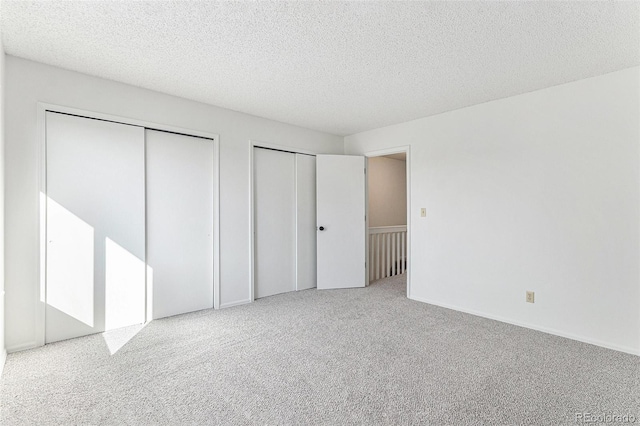480 W Rockrimmon Blvd Unit D, Colorado Springs, CO 80919 - unfurnished bedroom featuring multiple closets, carpet, and a textured ceiling