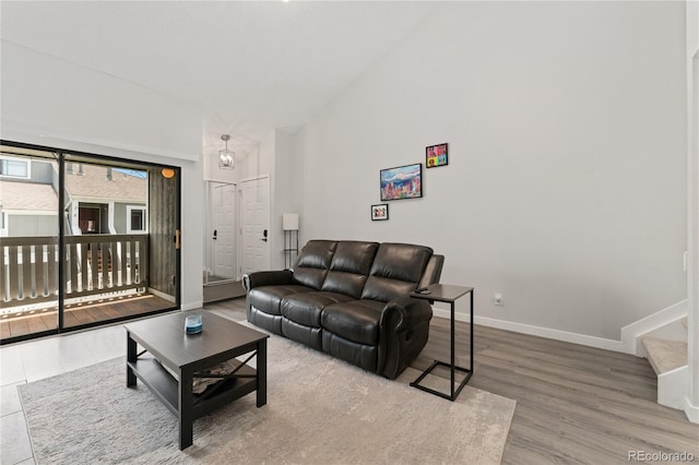 1160 S Monaco Pkwy Unit 6, Denver, CO 80224 - living room featuring high vaulted ceiling, wood finished floors, and stairway