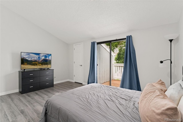 1160 S Monaco Pkwy Unit 6, Denver, CO 80224 - bedroom with access to outside, wood finished floors, vaulted ceiling, and a textured ceiling
