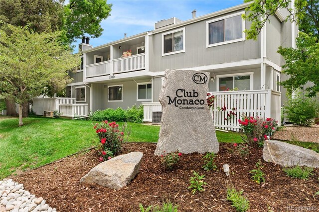 1160 S Monaco Pkwy Unit 6, Denver, CO 80224 - view of front of house with a balcony, a chimney, and a front lawn