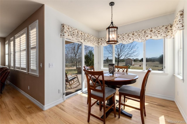 dining area with light wood-style floors and baseboards