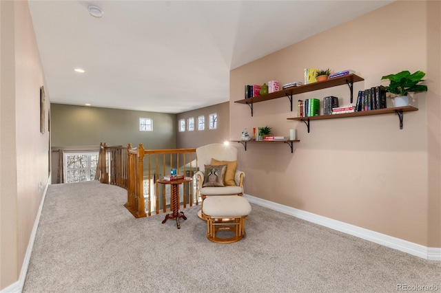 living area with baseboards, an upstairs landing, carpet, and a healthy amount of sunlight