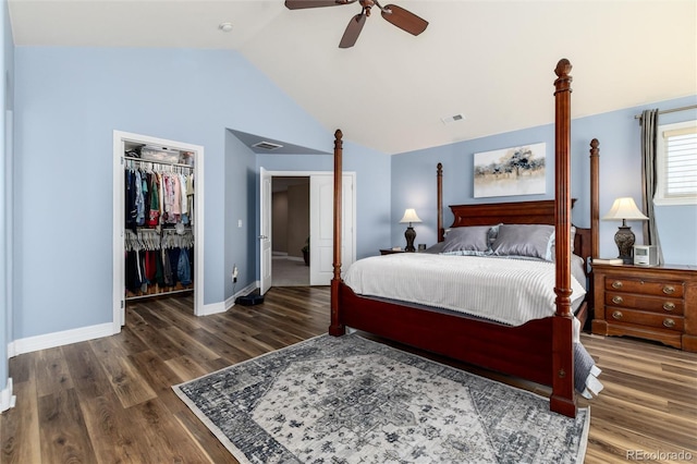 bedroom with baseboards, vaulted ceiling, a spacious closet, visible vents, and wood finished floors