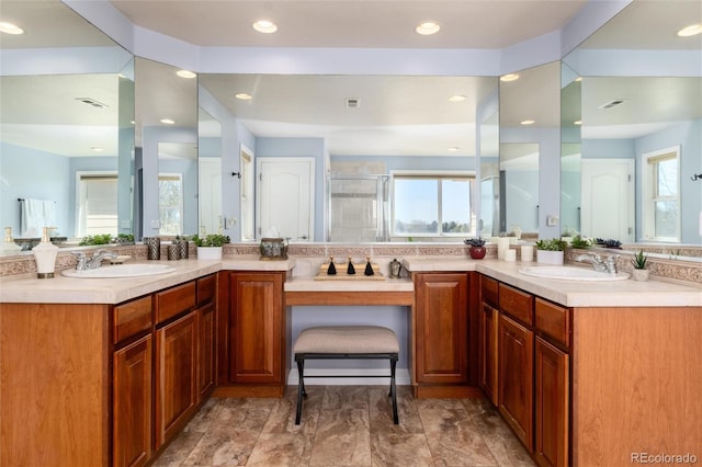 bathroom with a sink, visible vents, a shower stall, and double vanity