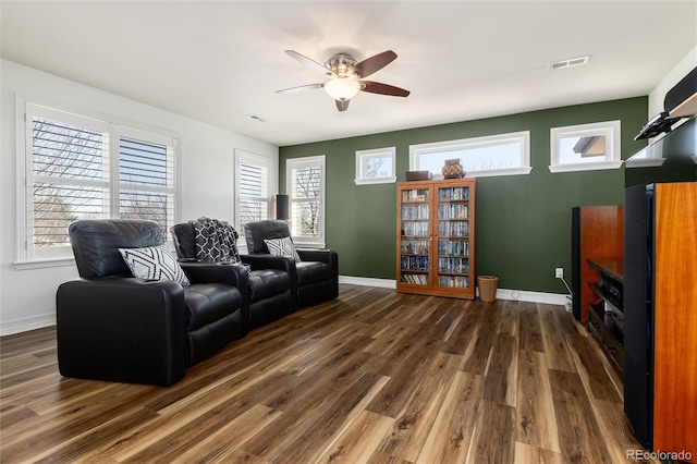 living area featuring dark wood-style floors, baseboards, visible vents, and ceiling fan