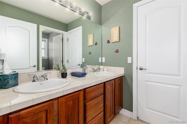full bathroom featuring tile patterned flooring, double vanity, and a sink