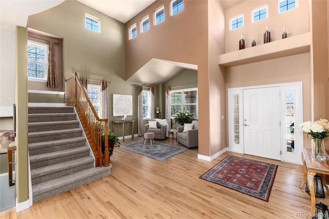 entryway featuring baseboards, stairway, and wood finished floors