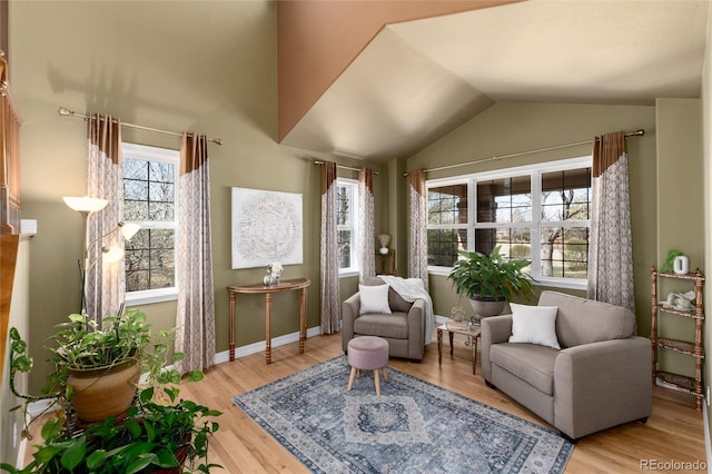sitting room featuring wood finished floors, baseboards, and lofted ceiling