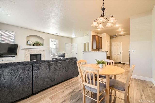 dining area featuring light hardwood / wood-style flooring and a notable chandelier