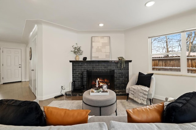 living room with light wood-type flooring and a tile fireplace