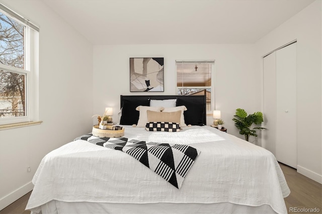 bedroom with wood finished floors and baseboards