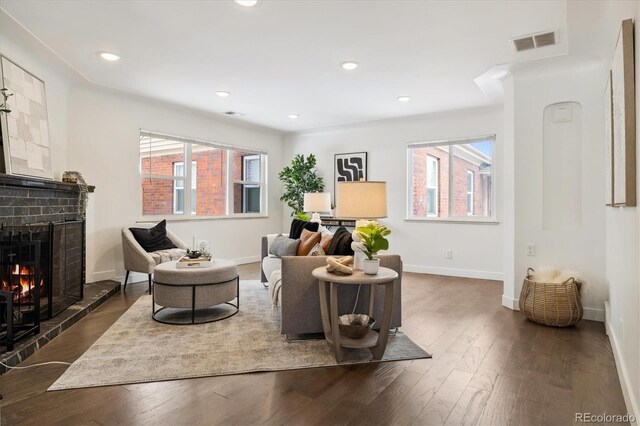 living area with dark wood-style floors, recessed lighting, visible vents, and baseboards