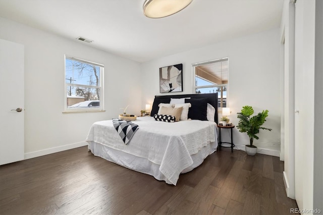 bedroom featuring baseboards and dark wood-type flooring