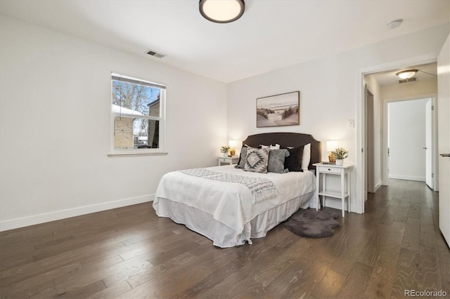 bedroom with dark wood-type flooring, visible vents, and baseboards