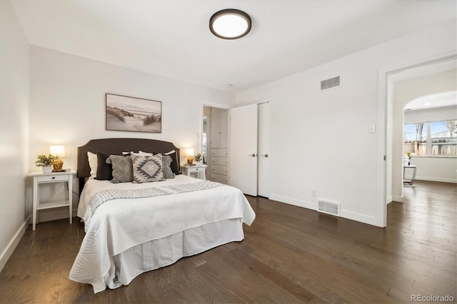 bedroom with baseboards, visible vents, and dark wood-style flooring