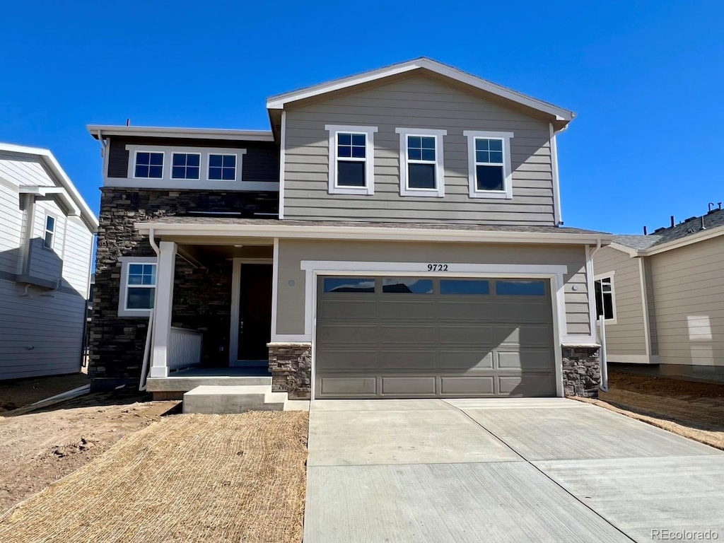 view of front facade featuring a garage, stone siding, and concrete driveway