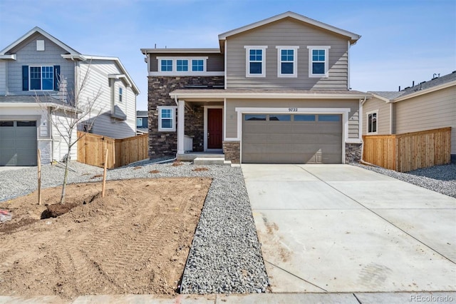 view of front facade with stone siding, an attached garage, driveway, and fence