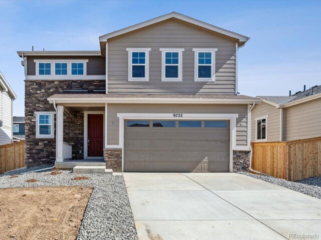 view of front facade featuring stone siding, concrete driveway, a garage, and fence