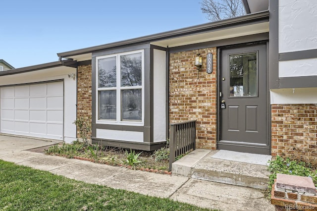 property entrance featuring brick siding and a garage