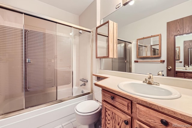 bathroom featuring toilet, tile patterned floors, vanity, and combined bath / shower with glass door