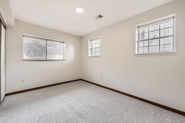 unfurnished bedroom with carpet floors, baseboards, and visible vents