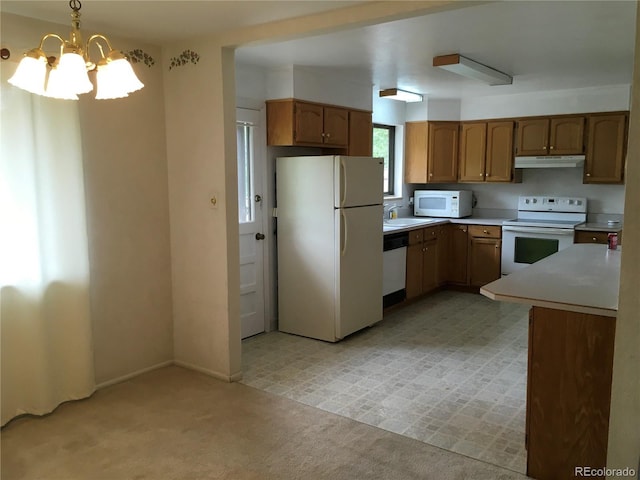 6411 W 82nd Dr, Arvada, CO 80003 - kitchen featuring white appliances, under cabinet range hood, light countertops, a chandelier, and light colored carpet