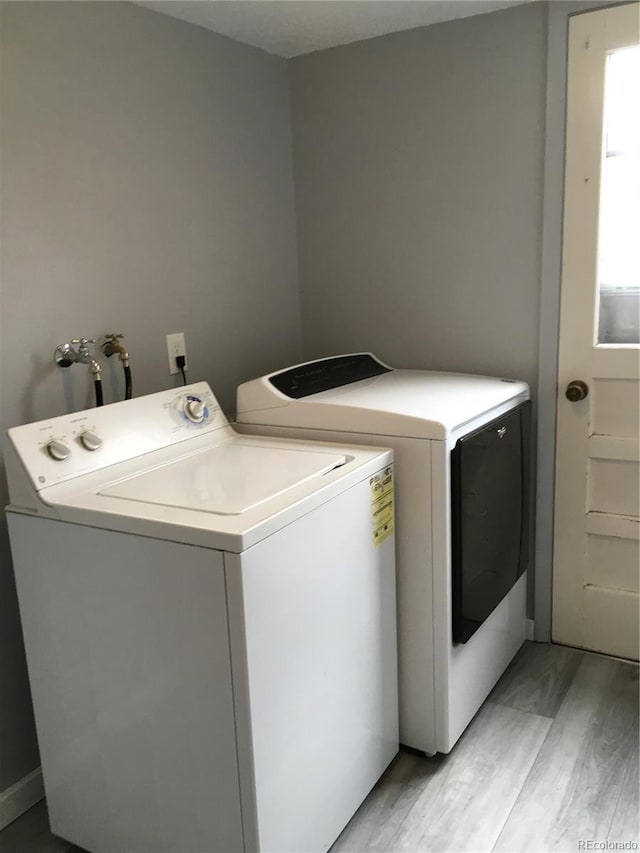 6411 W 82nd Dr, Arvada, CO 80003 - laundry area featuring washer and dryer, light wood-style floors, and baseboards