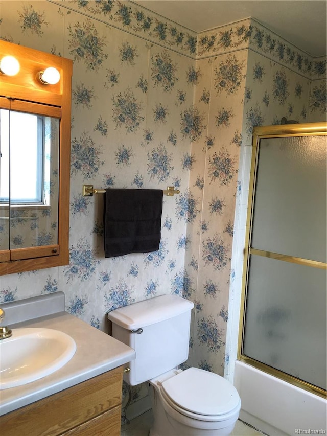 6411 W 82nd Dr, Arvada, CO 80003 - full bath with vanity, toilet, shower / bath combination with glass door, and wallpapered walls
