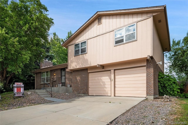 6411 W 82nd Dr, Arvada, CO 80003 - split level home with brick siding, concrete driveway, a chimney, and a garage