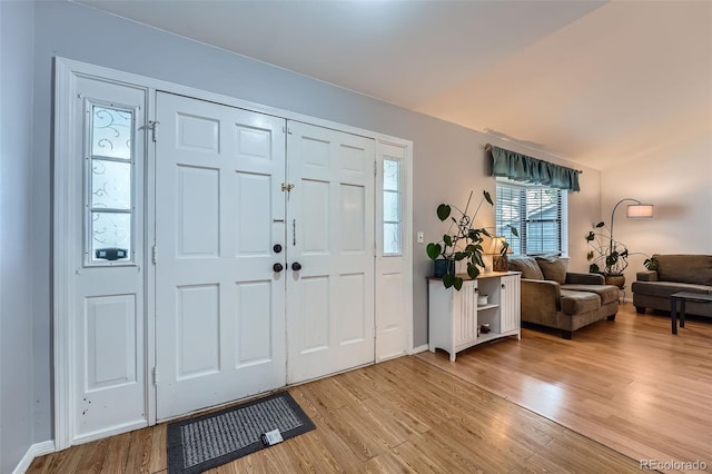 foyer entrance featuring baseboards and light wood finished floors
