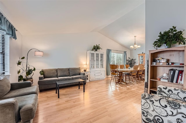living room with an inviting chandelier, light wood-style floors, and lofted ceiling