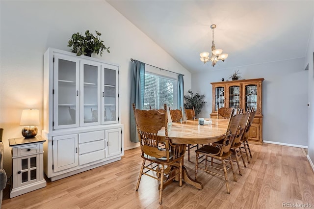 dining room featuring an inviting chandelier, baseboards, vaulted ceiling, and light wood-type flooring