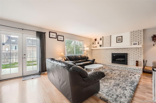 living room featuring french doors, a healthy amount of sunlight, and light wood-type flooring