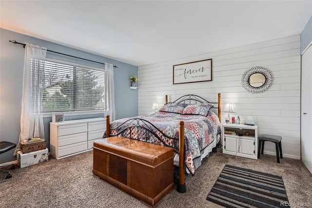 bedroom with carpet flooring and wooden walls