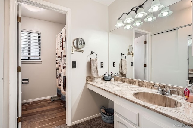 full bathroom featuring baseboards, vanity, and wood finished floors