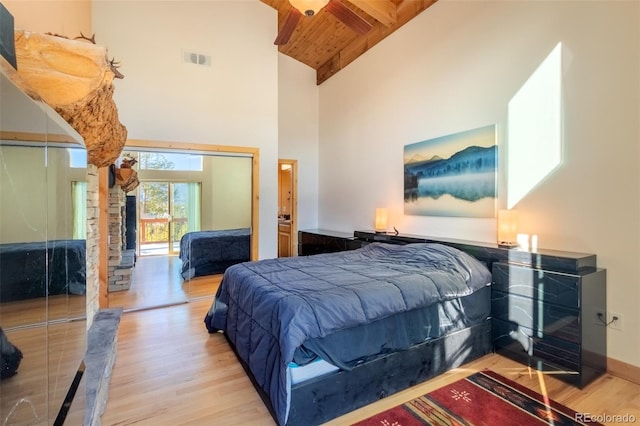 bedroom with beam ceiling, high vaulted ceiling, light hardwood / wood-style floors, and wood ceiling