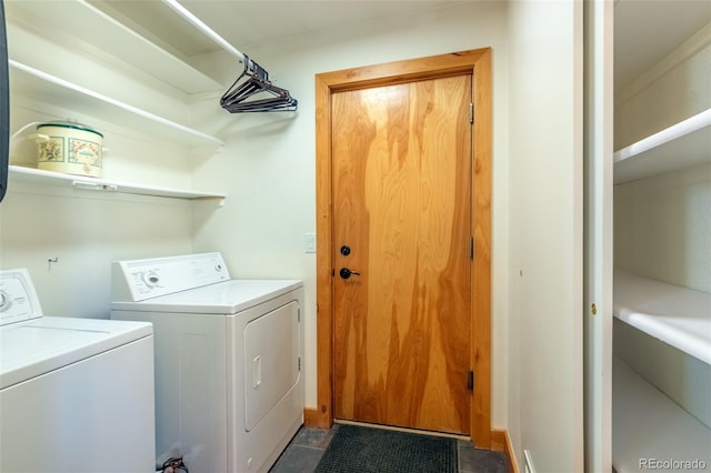 clothes washing area featuring dark tile patterned flooring and independent washer and dryer