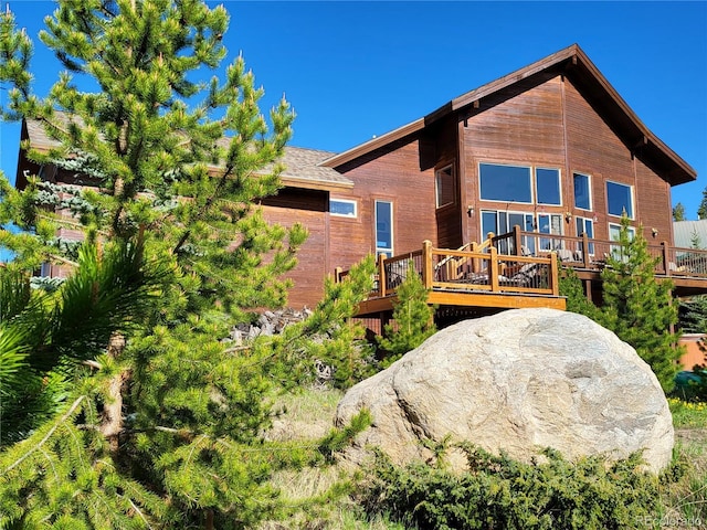 rear view of property featuring a deck