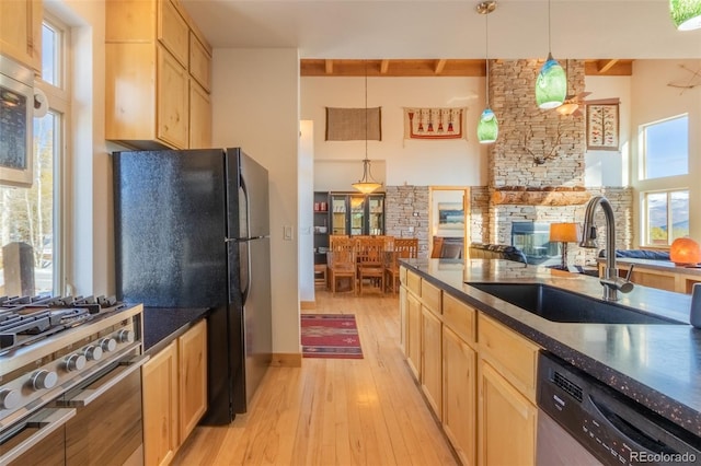 385 Trail Ridge Dr, Grand Lake, CO 80447 - kitchen with a sink, beam ceiling, appliances with stainless steel finishes, a towering ceiling, and light wood-style floors