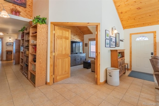 entrance foyer featuring high vaulted ceiling, wooden ceiling, light colored carpet, and light tile patterned floors