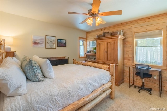 bedroom featuring light carpet, ceiling fan, and wooden walls