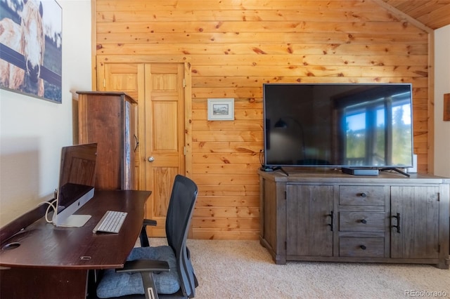 office area with light carpet, wood walls, and vaulted ceiling