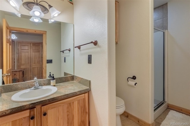 bathroom featuring baseboards, toilet, tile patterned flooring, vanity, and a shower stall