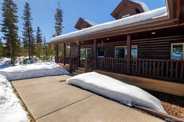 view of snow covered exterior with covered porch