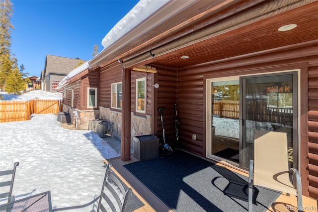 snow covered patio featuring fence