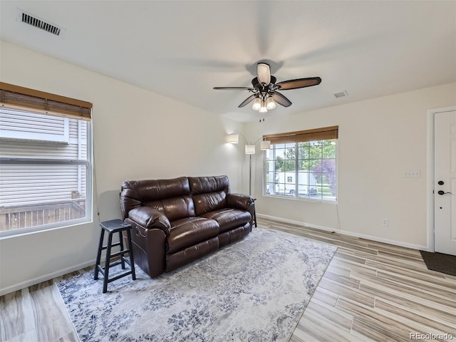 living room featuring ceiling fan and light hardwood / wood-style flooring