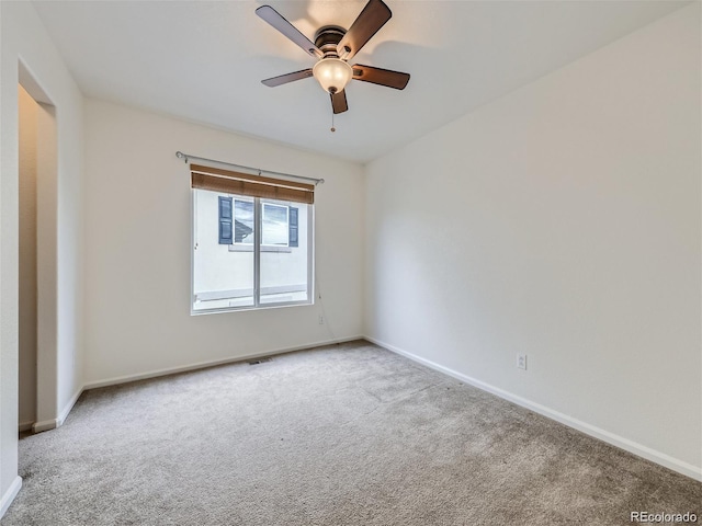 carpeted spare room with ceiling fan