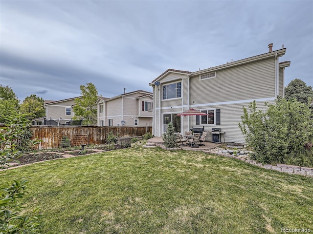 back of property featuring a lawn and a patio area