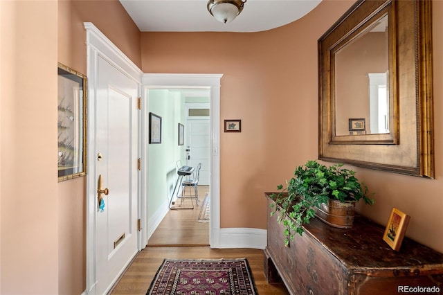 hallway with baseboards and wood finished floors