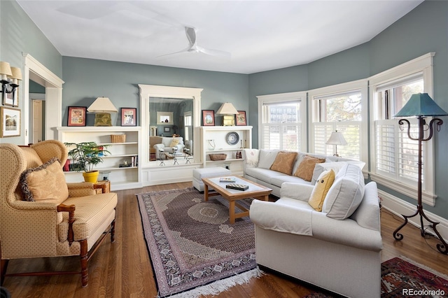 living area featuring ceiling fan, baseboards, and wood finished floors